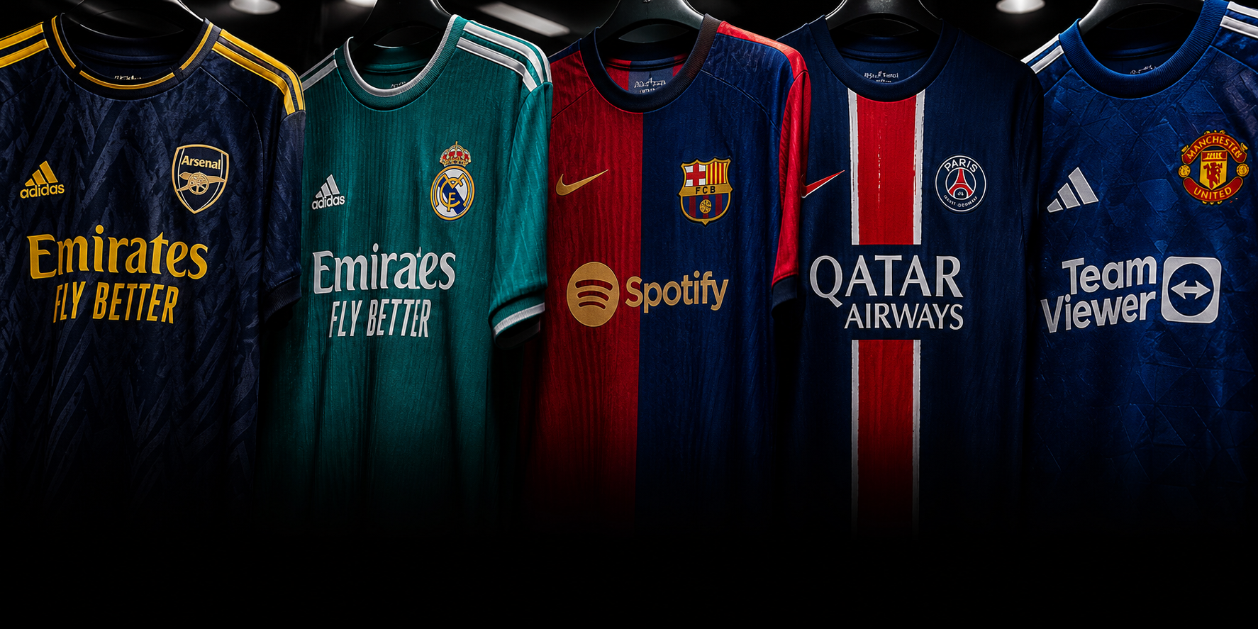 Football shirts from major clubs displayed in a dark retail gallery